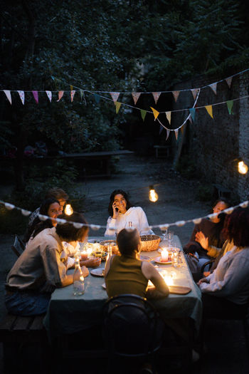 Friends enjoying dinner party in back yard decorated with bunting