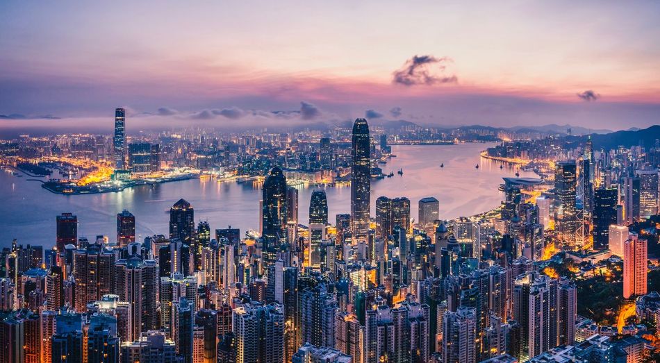 Modern buildings at victoria harbour during sunset in city
