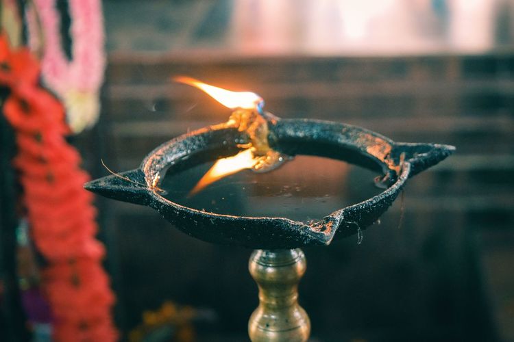 Close-up of lit oil lamp in temple