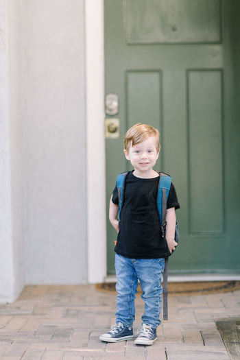 Portrait of smiling boy standing against entrance