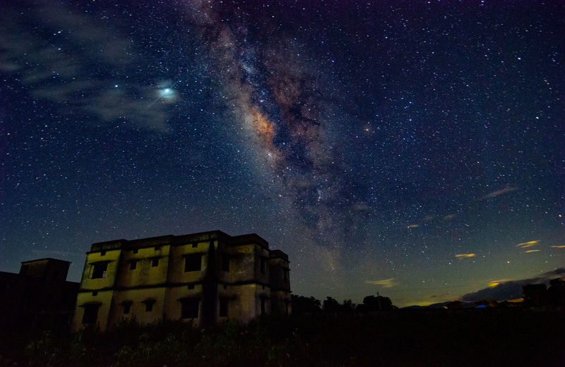 Low angle view of building against milkyway at night