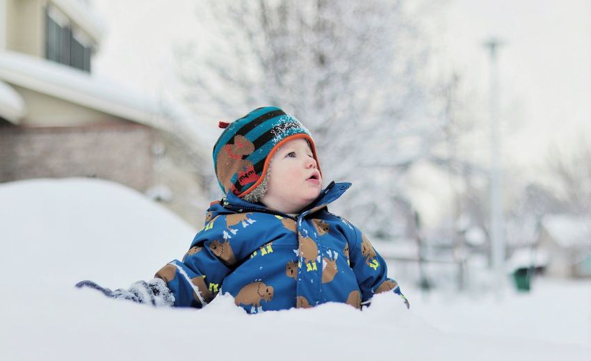 Cute boy looking at snow during winter