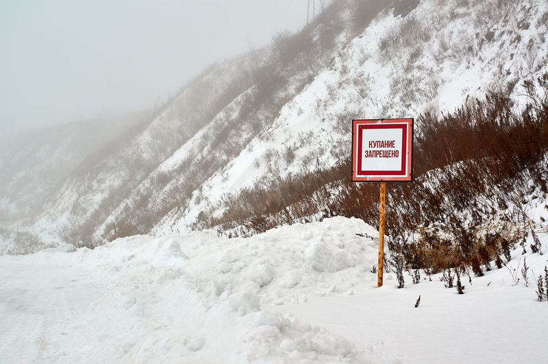Information sign on snow covered mountain