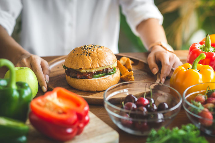 Close-up of woman with burger on table