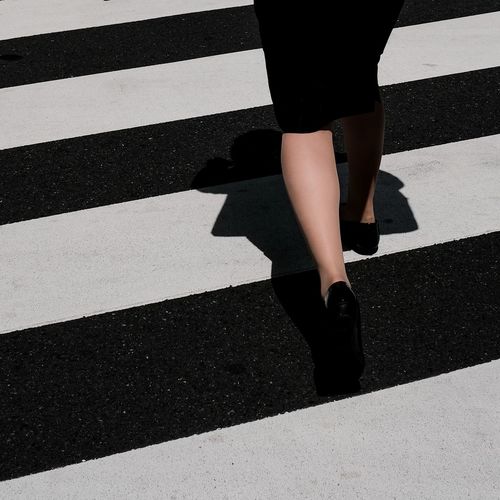 Low section of woman walking on road