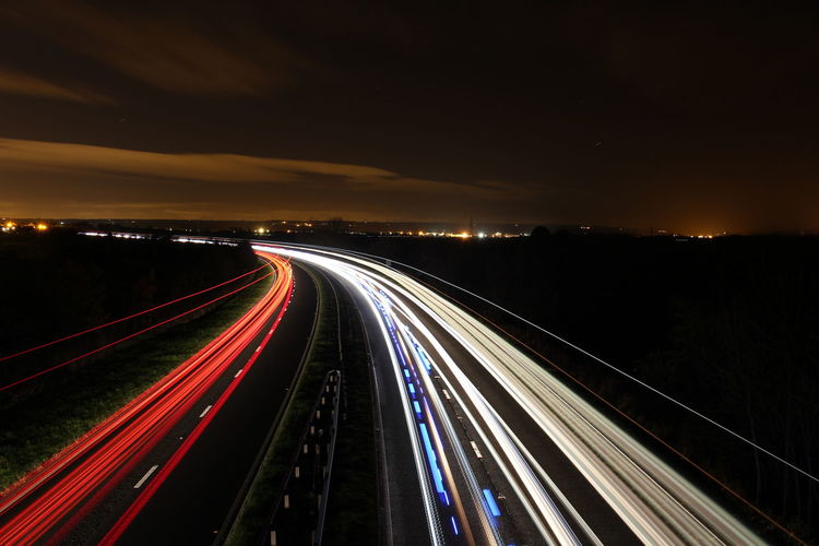 High angle view of illuminated light trails on road at night