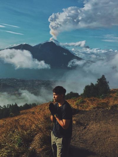Man standing on mountain against sky