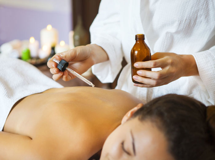 Midsection of woman holding oil bottle at spa