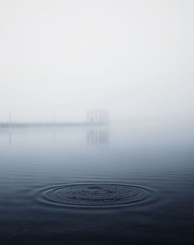 Scenic view of lake against sky during foggy weather