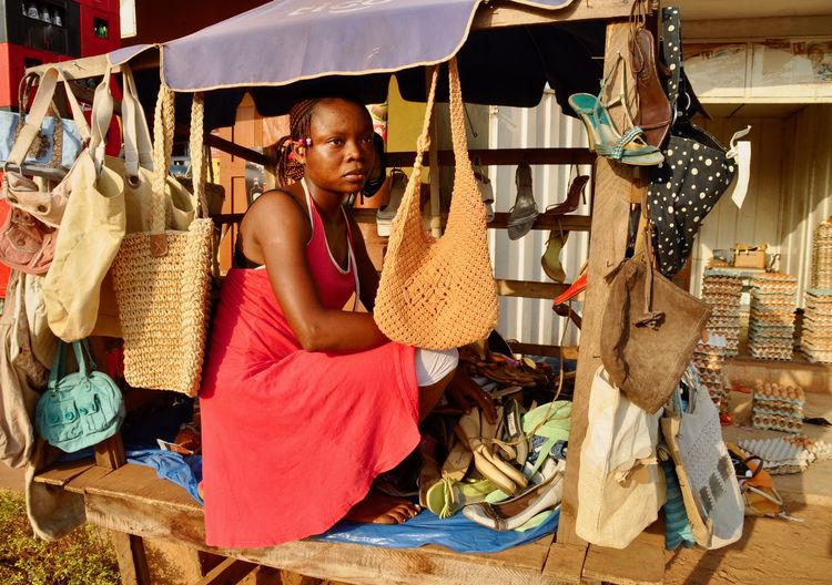 Woman looking away while selling purses in market