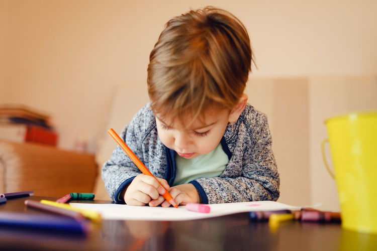Boy drawing on table at home