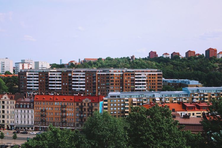 Residential buildings in green area against clear sky