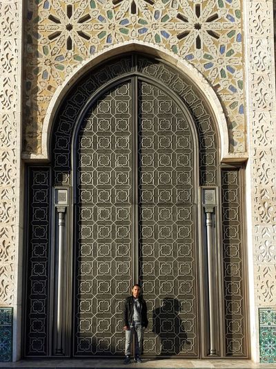 Full length of man standing against door of building