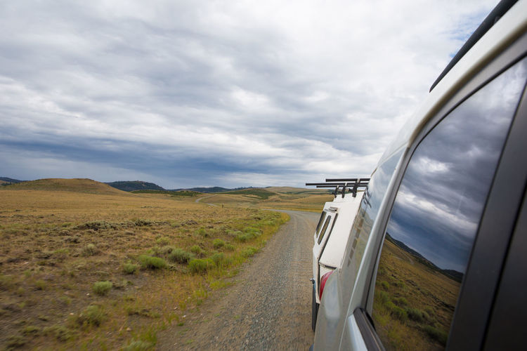 Road amidst field against sky
