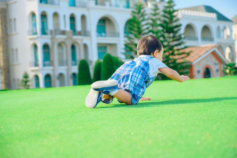 Rear view of boy sitting on grass