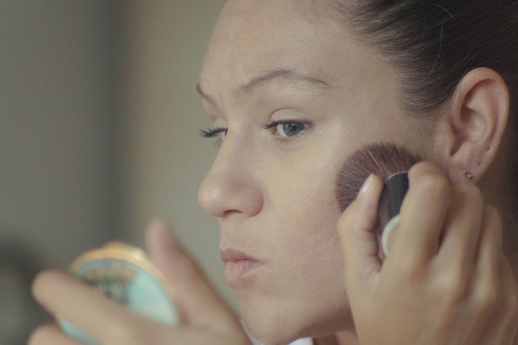 Close-up of woman applying make-up