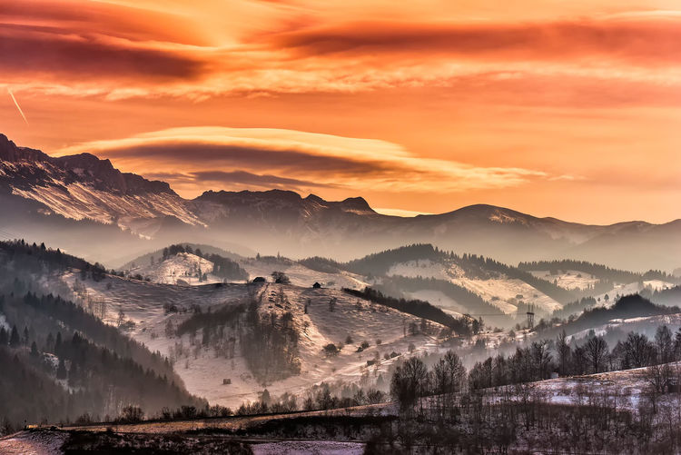 Scenic view of mountains against orange sky