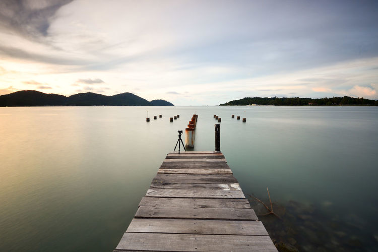 Pier over lake against sky