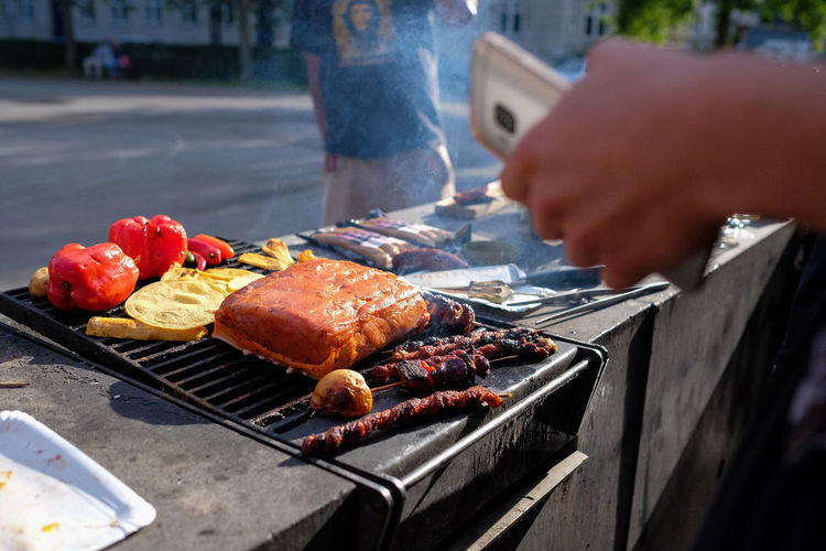 Fresh food grilling on barbecue against road