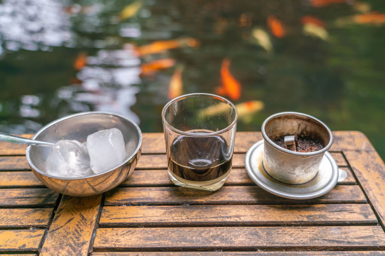 Traditional vietnamese coffee with the koi fish pond background