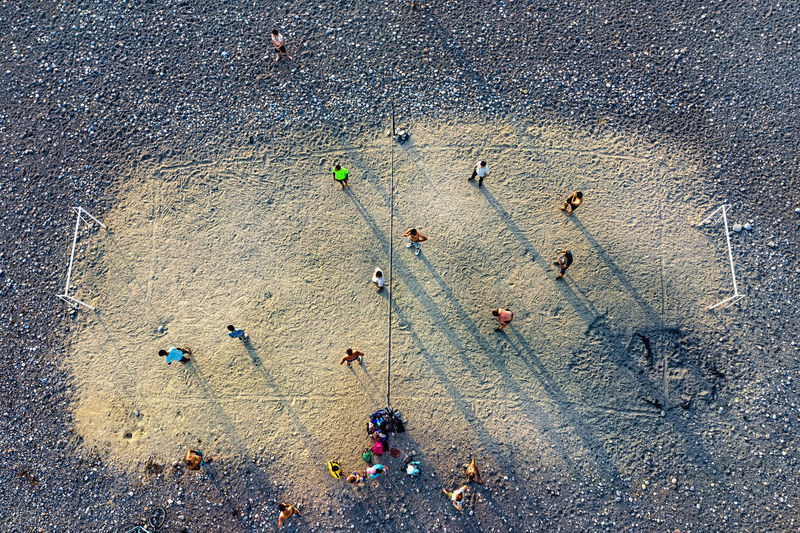 Drone view of people playing soccer at beach