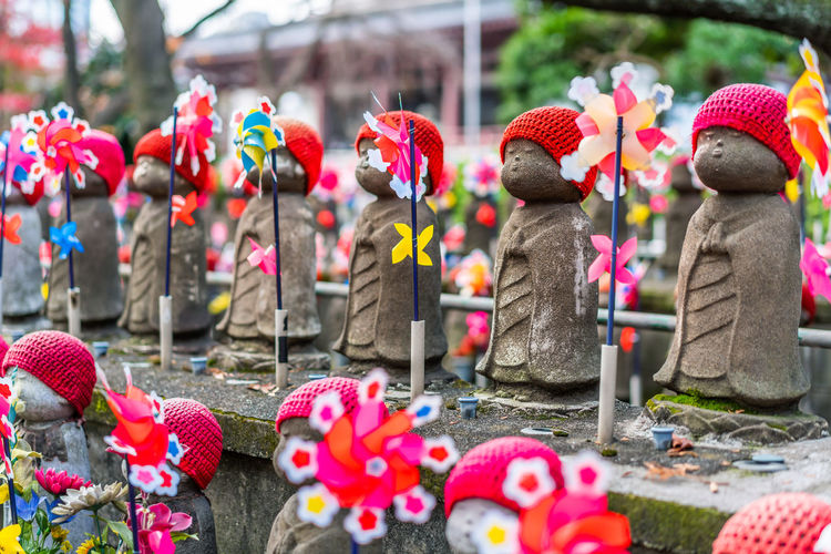 Close-up of statues by pinwheel toy in temple