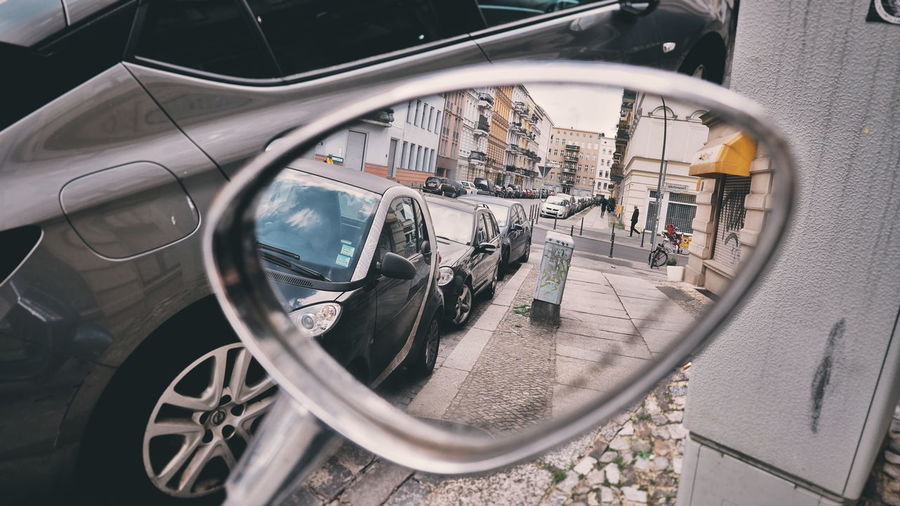 Reflection of street in side-view mirror of car
