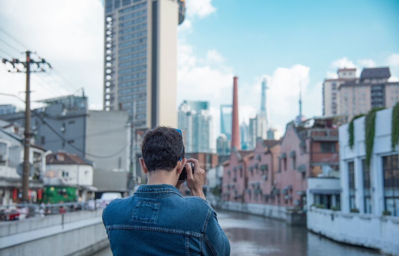 Rear view of man photographing cityscape