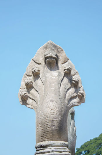Low angle view of snake statue against clear blue sky
