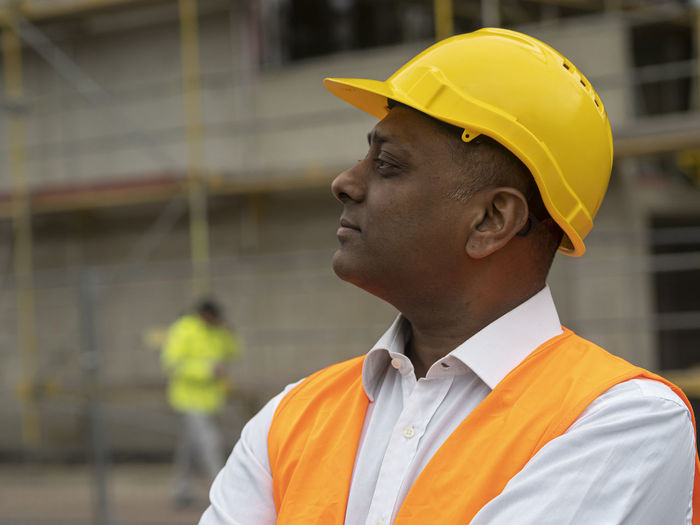 Side view of man looking at construction site