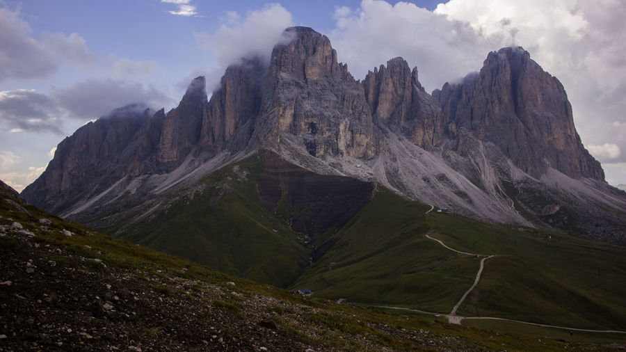 Scenic view of landscape and dolomites mountains against sky