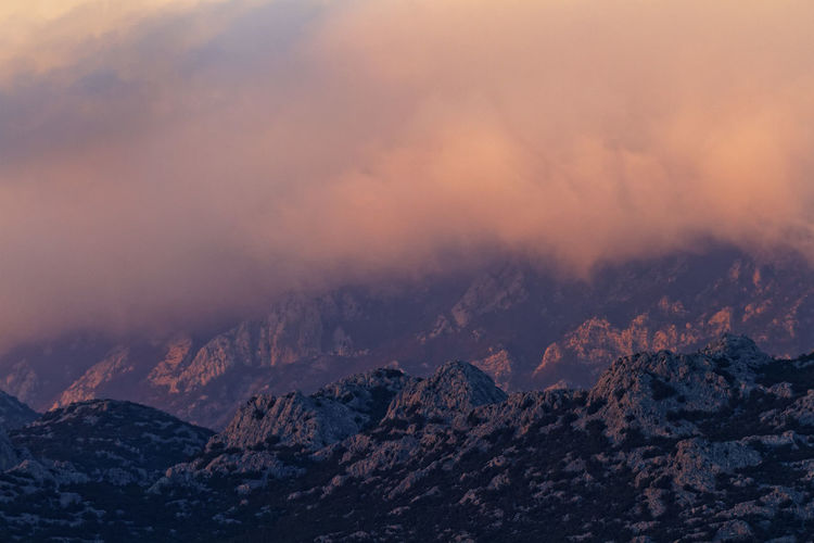 Scenic view of clouds above velebit  mountains against sky during sunset