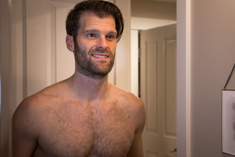 Portrait of shirtless man standing at home