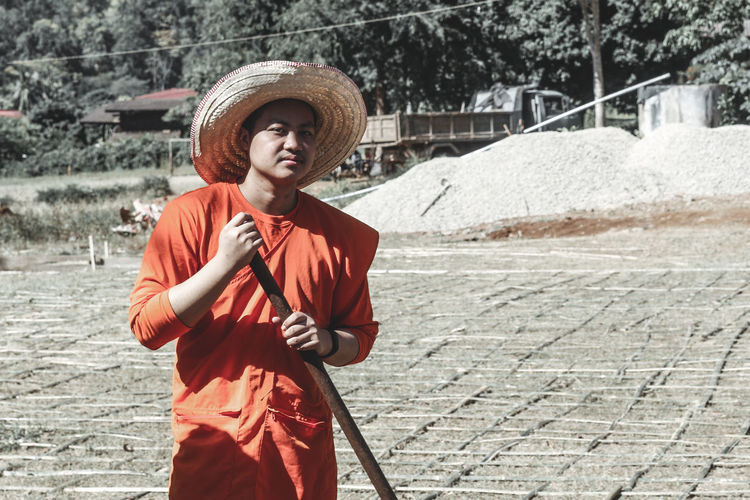 Full length of man wearing hat standing against water