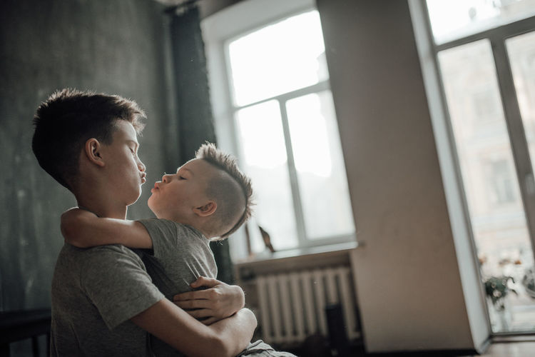 Side view of father with baby at window