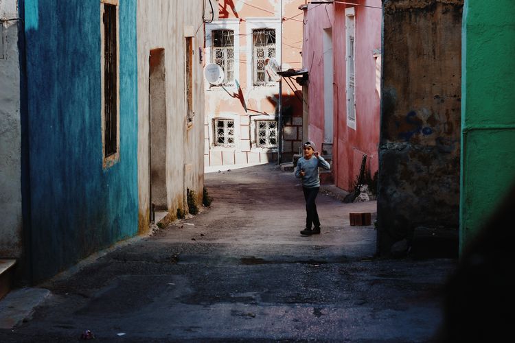 Man walking on footpath amidst buildings