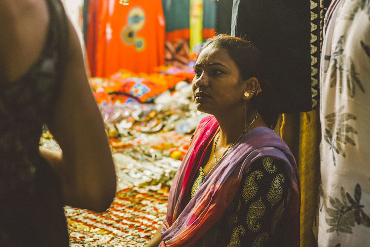 Rear view of people in traditional clothing of woman in the market selling