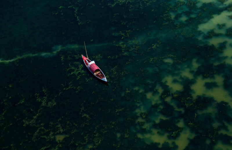 HIGH ANGLE VIEW OF BOAT IN WATER AGAINST SKY