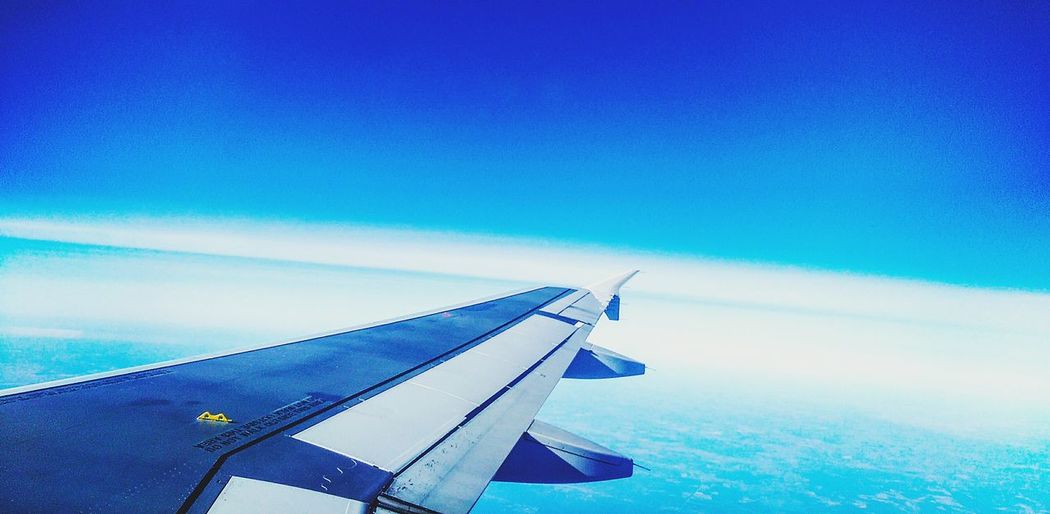 Airplane wing against clear blue sky