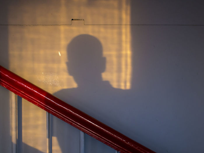 Shadow of man on wall during sunset