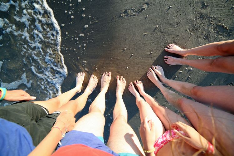 Ten barefoot feet of a family of five on the beach with mum dad and children