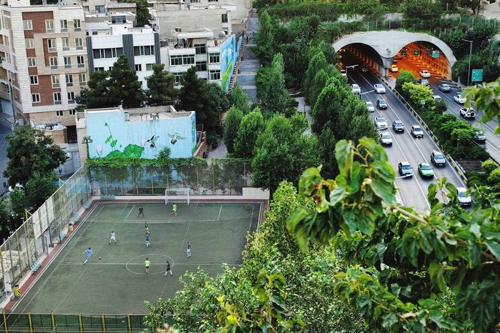 High angle view of men playing on soccer field in city