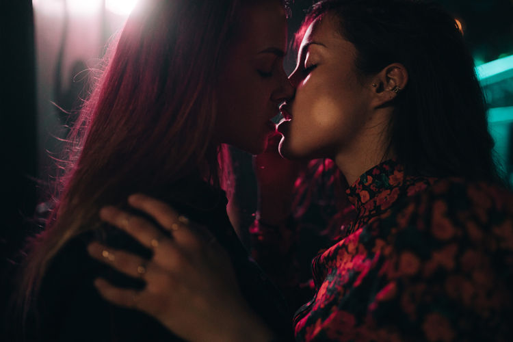 Close-up of lesbian couple embracing kissing outdoors