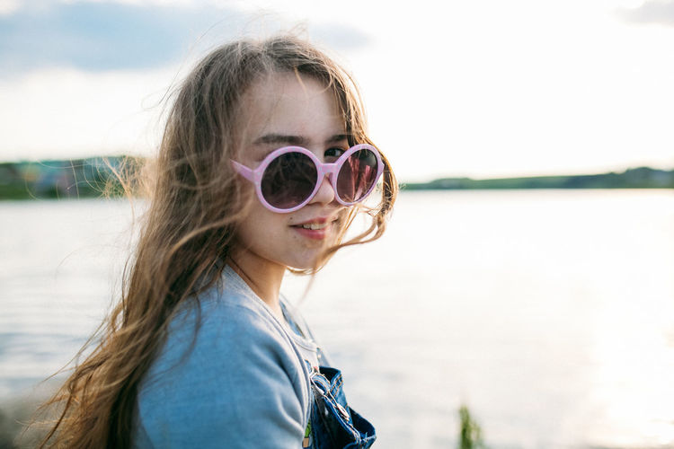 Portrait of girl wearing sunglasses against sky