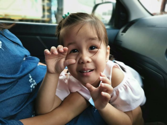Portrait of cute girl sitting in car or smile