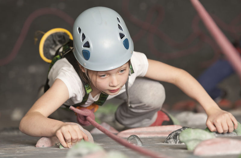 Young girl climbing at indoor climbing wall in england / uk