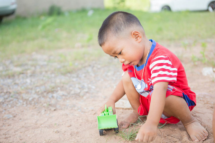 Side view of cute boy playing on land
