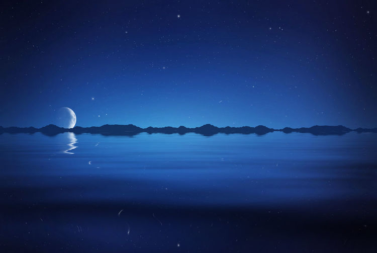 Idyllic view of lake against blue sky at night