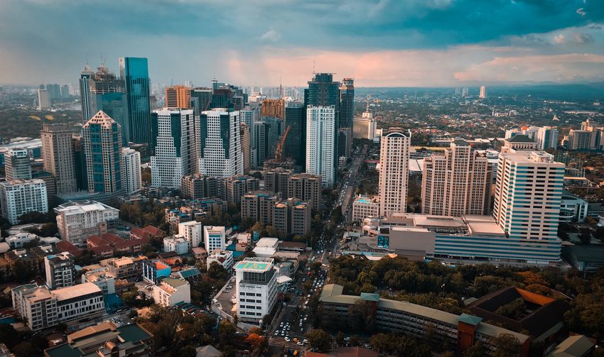 Aerial view of buildings in city against sky