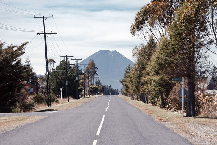 Empty road with trees in background